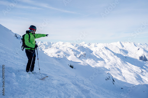 Sportive man pointing hand away while skiing on snowy slope .