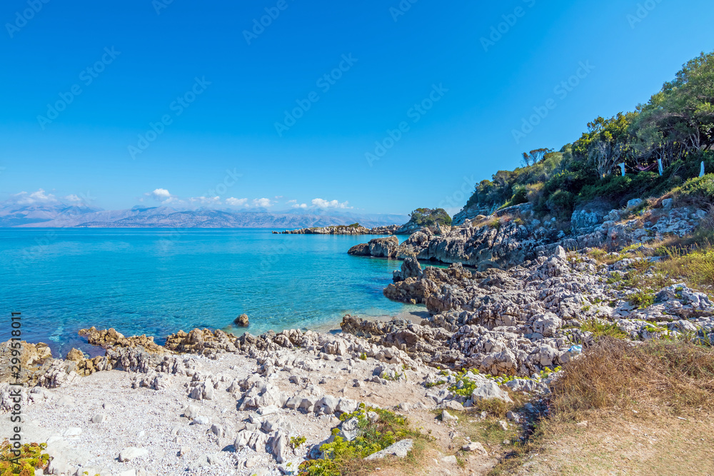 Rocky beach landscape on summer day, Beautiful turquoise color sea water. Corfu, Greece.