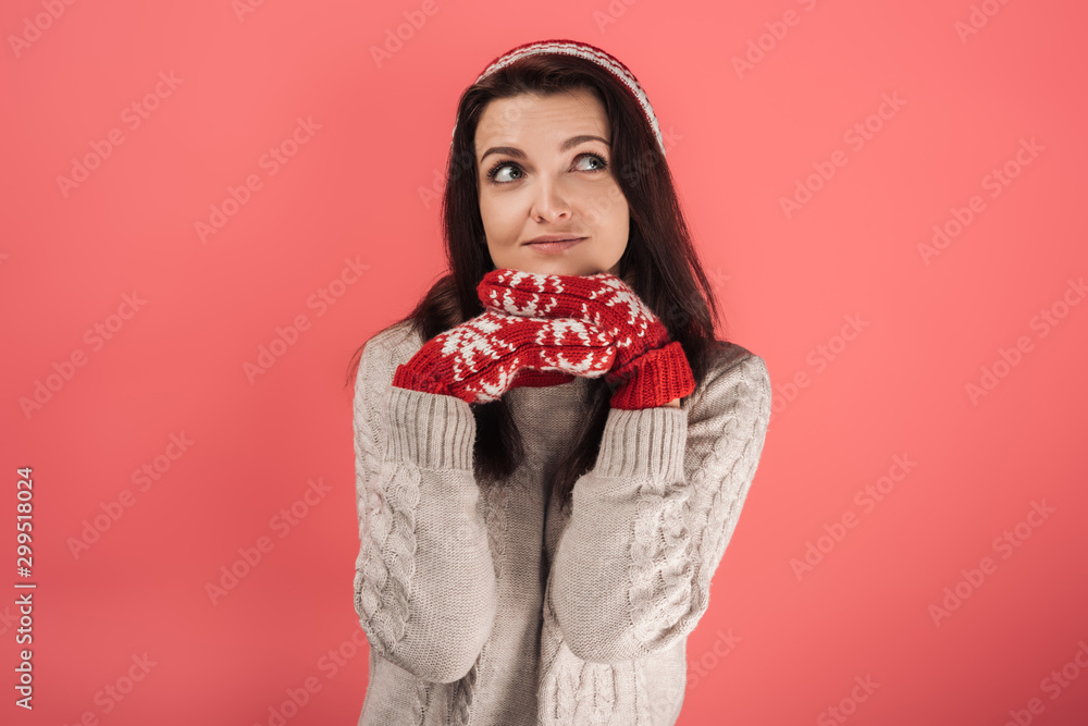 dreamy woman in red knitted hat and gloves touching face on pink dreamy woman in red knitted hat and gloves touching face on pink