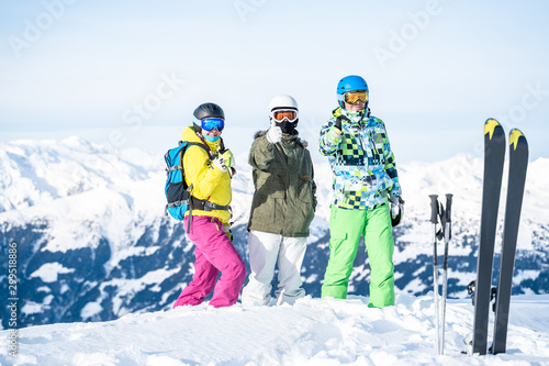 Photo of three athletes holding hand up at ski resort.