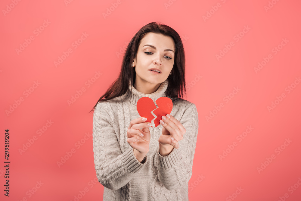 woman in warm sweater holding paper cut with broken heart on pink woman in warm sweater holding paper cut with broken heart on pink