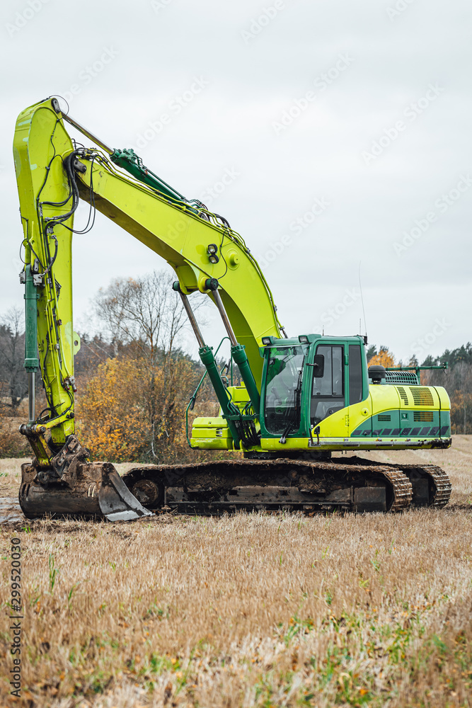 Modern excavator performs excavation work on the farm field. Modern excavator performs excavation work on the farm field.