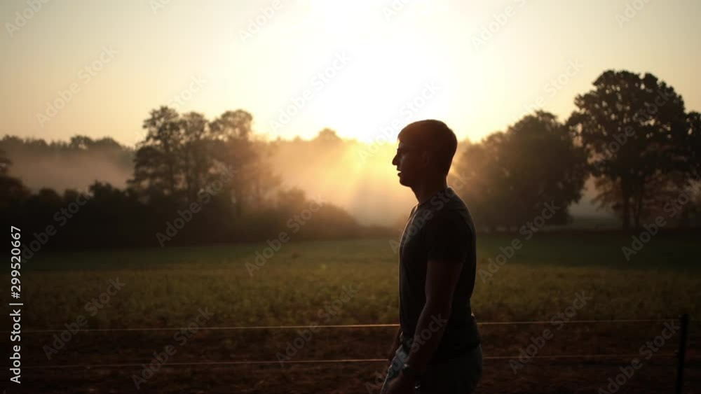 Silhouette male person having morning walk with foggy sunrise, lateral Silhouette male person having morning walk with foggy sunrise, lateral