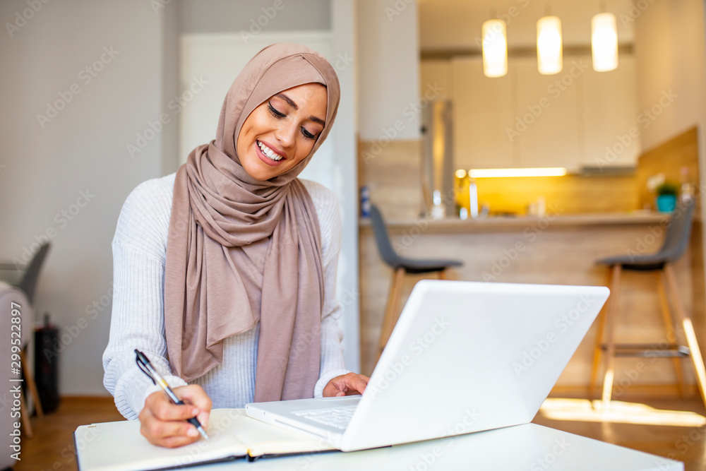 Free Photo  Attractive female arabic working on laptop computer and  paperworks on desk arabian businesswoman working at home dedication and  technology essential for getting her tasks done