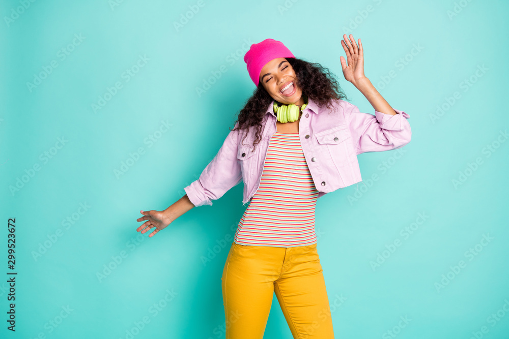 Photo of cheerful positive style casual cute nice pretty carefree girl wearing pants trousers yellow headphones striped t-shirt expressing emotions eye closed isolated pastel teal color background Photo of cheerful positive style casual cute nice pretty carefree girl wearing pants trousers yellow headphones striped t-shirt expressing emotions eye closed isolated pastel teal color background