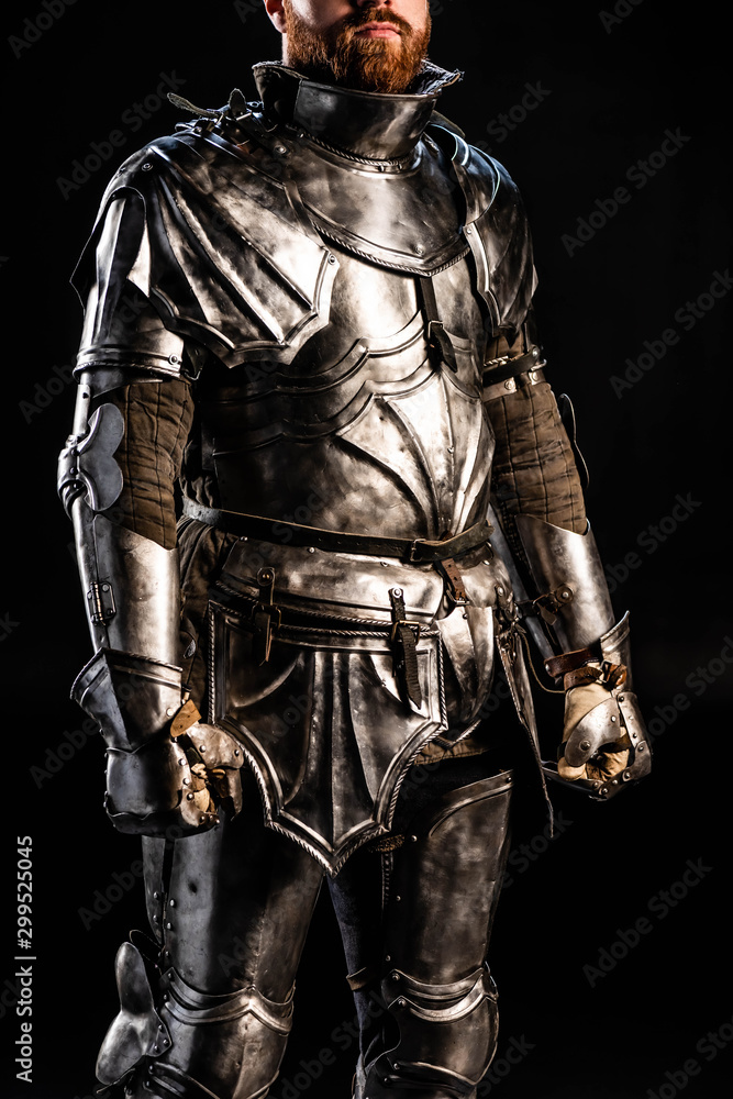 cropped view of knight in armor isolated on black