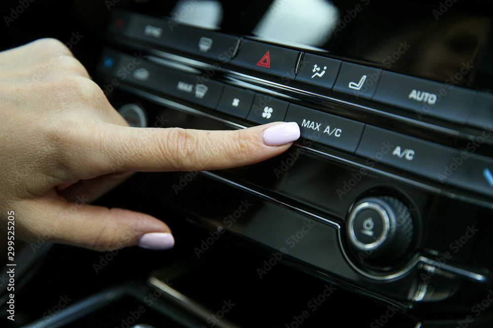 driver's finger presses the button for maximum air conditioning inside the car driver's finger presses the button for maximum air conditioning inside the car