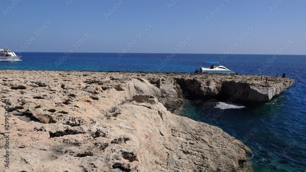 Sealand cliff patches at Cyprus exotic lagoon island with yachts arriving, wide panning shot Sealand cliff patches at Cyprus exotic lagoon island with yachts arriving, wide panning shot