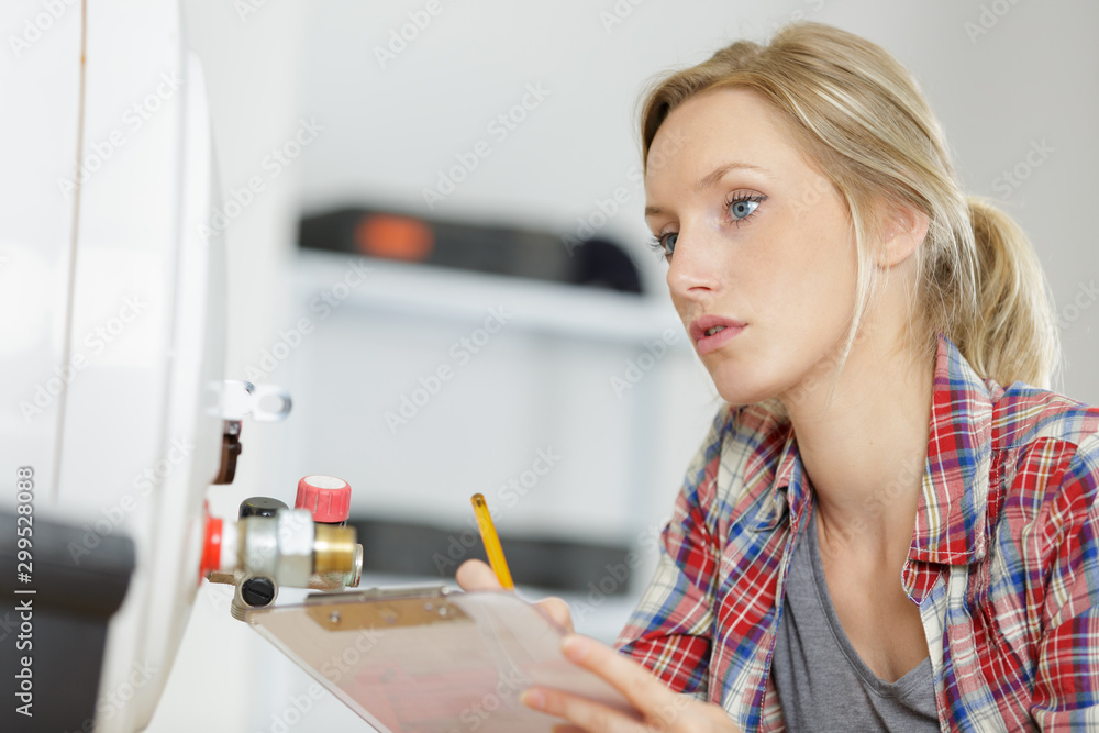 female plumber working on central heating boiler female plumber working on central heating boiler
