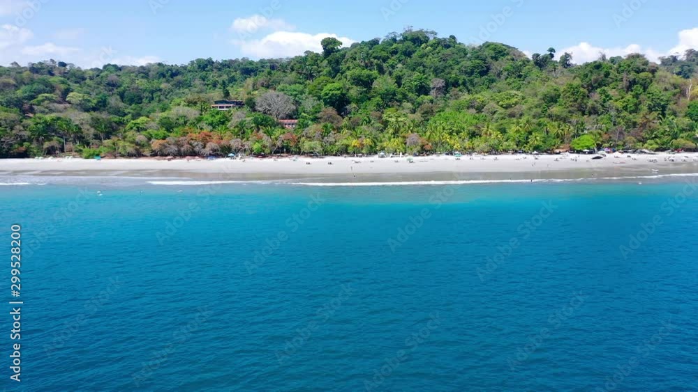Aerial: Tropical Beach With Lounge Chairs and Umbrellas With Untamed Lush Jungle Behind - Playa Espadilla, Costa Rica Aerial: Tropical Beach With Lounge Chairs and Umbrellas With Untamed Lush Jungle Behind - Playa Espadilla, Costa Rica