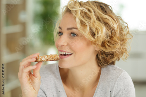 beautiful woman eating a cereal bar photo