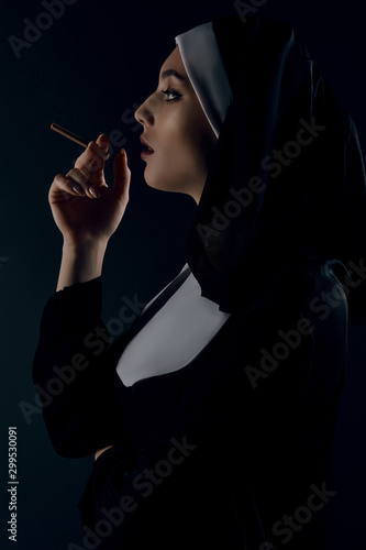 Принти на полотні Profile shot of upper nun's body, posing on black background
