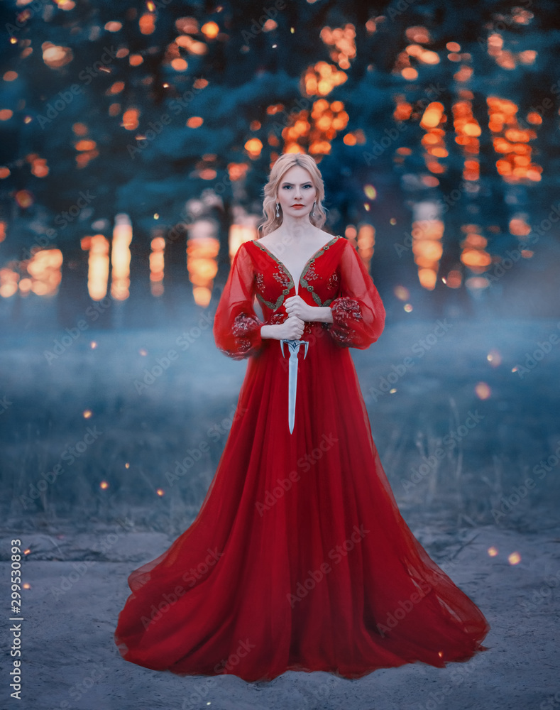 Beautiful, dangerous blonde queen in a red fashion lush dress with a dagger  in her hands.
