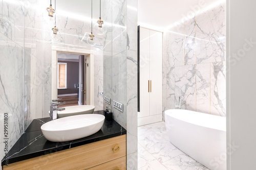 Stylish  modern luxurious marble bathroom with original fixtures and a washbasin