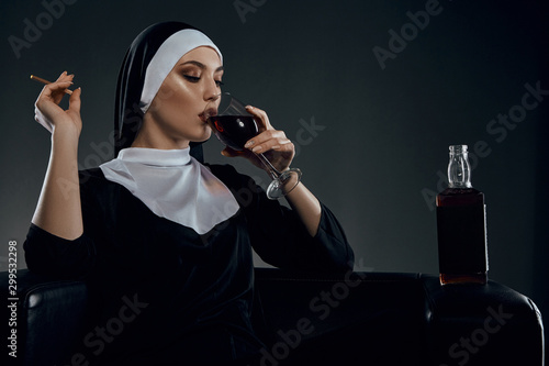 Принти на полотні Cropped half-turn shot of a nun, sitting on a chair
