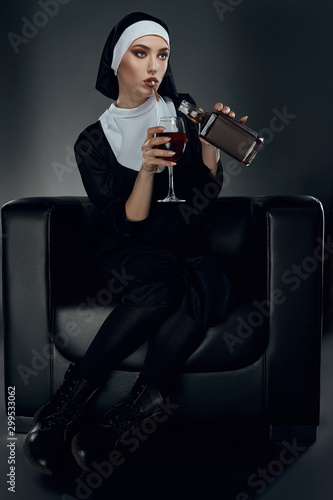 Fotografía Full length shot of a nun, sitting on a chair