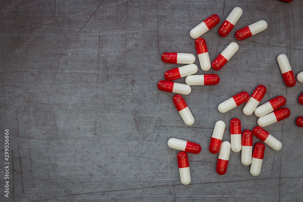 Red drugs pills capsules on dark moody background overdose concept Red drugs pills capsules on dark moody background overdose concept