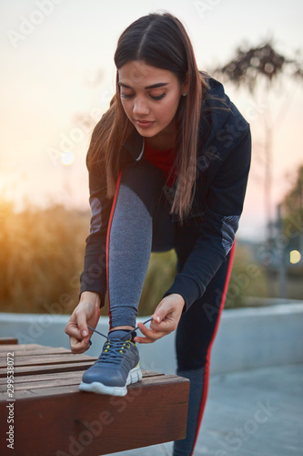 Young woman doing exercise in an urban park. © astrosystem