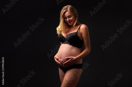 beautiful pregnant woman holds belly with hands © Himchenko