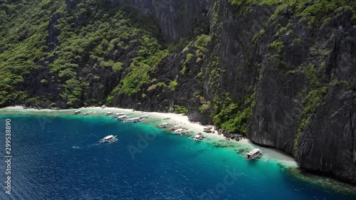 Beautiful Limestone mountains of the white Talisay Beach in El Nido, full of boats and tourists, aerial shot in Palawan, Philippines photo