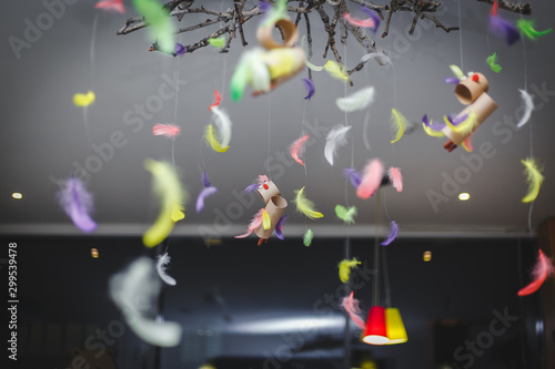 multi-colored feathers hanging on threads to the ceiling. kids atmosphere room lesson classes in school or kindergarten or education centre.