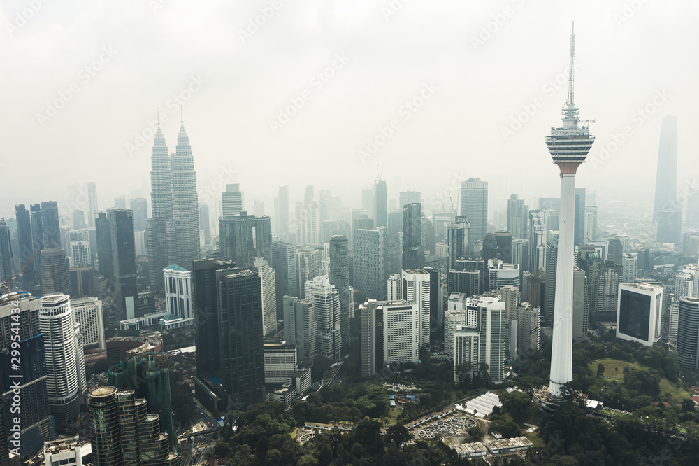View from above, stunning aerial view of Kuala Lumpur skyline with the magnificent KL Tower and other skyscrapers during a foggy day. Kuala Lumpur, Malaysia