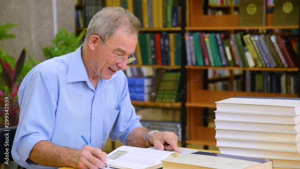 senior man reading a book in the library senior man reading a book in the library