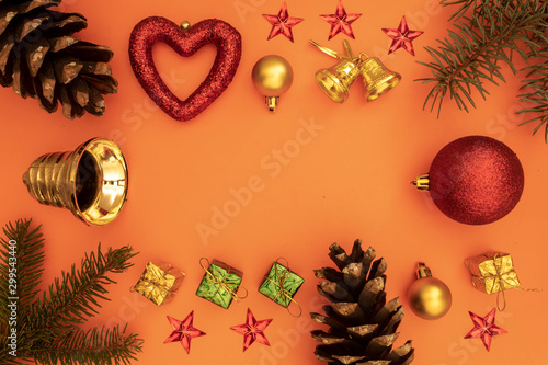 Decoration for Christmas and New Year Greeting Card With Colorful Gift Boxes, Red Decorative Ball, Christmas Yellow Bell, Pine Tree Branches and Empty Space in The Middle on Orange Background