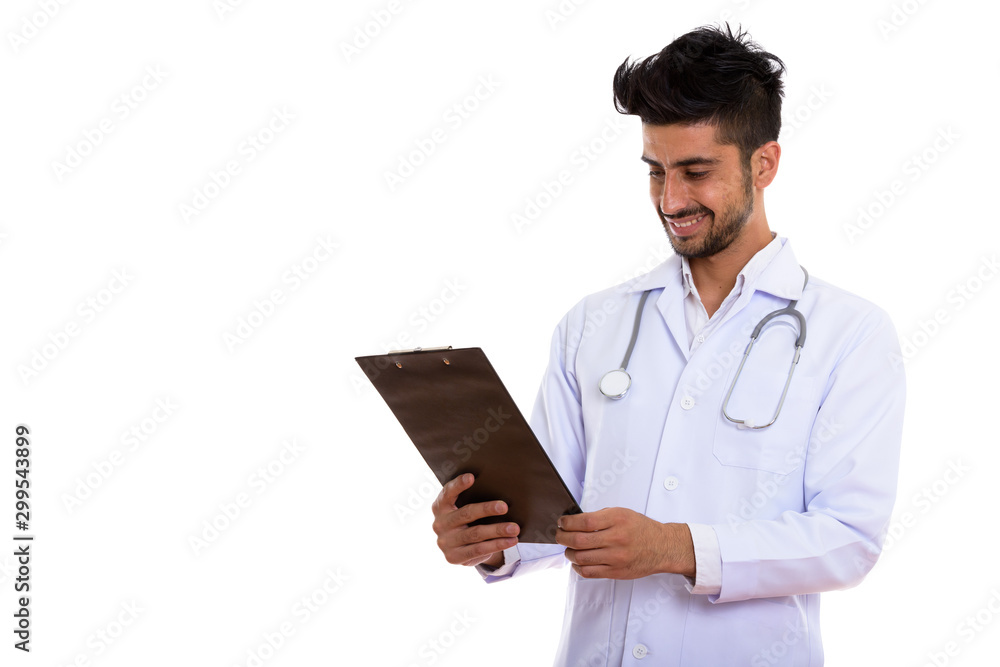 Portrait of young handsome bearded Persian man doctor holding clipboard Portrait of young handsome bearded Persian man doctor holding clipboard