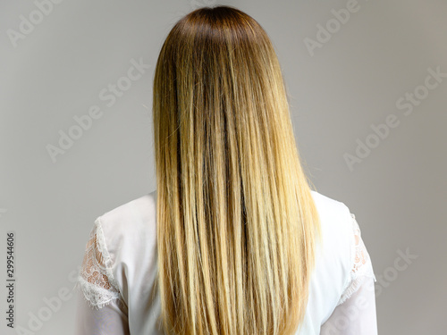 Studio large photo portrait of a beautiful girl with long beautiful hair and excellent make-up on a gray background. Rejuvenation of the skin of the face.