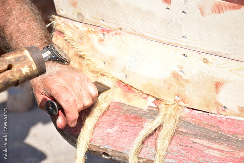 calafataggio di una piccola barca in legno,  Sferracavallo, Palermo, Sicilia