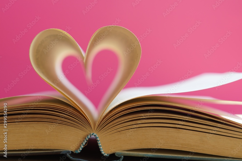 Heart from page of book for valentine's day concept with blurred bright light background and pink tone. Heart from page of book for valentine's day concept with blurred bright light background and pink tone.