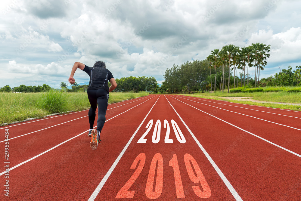 The start into the new year 2020. Start up of runner man running on race track go to Goal of Success. People running as part of Number 2019 to 2020. Holiday sport Concept The start into the new year 2020. Start up of runner man running on race track go to Goal of Success. People running as part of Number 2019 to 2020. Holiday sport Concept