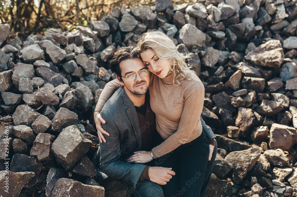Couple in love embraced and sitting on stones Couple in love embraced and sitting on stones
