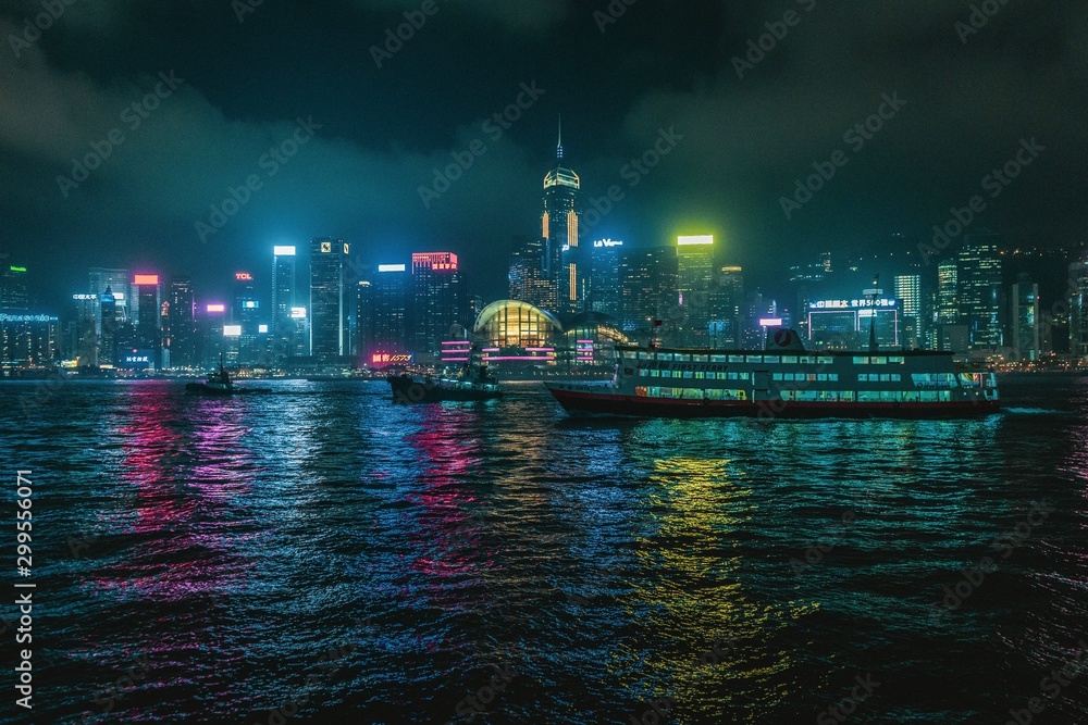 Naklejka premium Hongkong at night with skyline and tourist boat