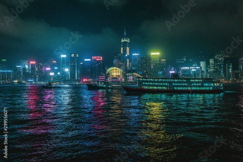 Hongkong at night with skyline and tourist boat