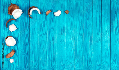 pieces of fresh coconut on a turquoise wooden background photo