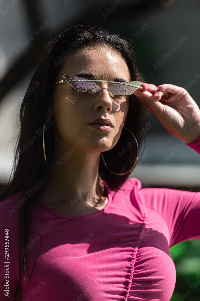 Fototapeta premium attractive woman in dress and sunglasses posing and looking at camera outside