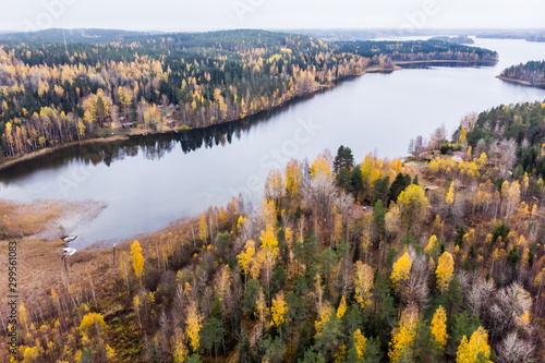 Fototapeta Naklejka Na Ścianę i Meble -  Aerial view of lake and colorful forests on a autumn day in Finland. Drone photography