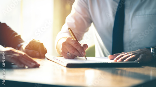 Closeup Businessman signing a contract investment professional document agreement on the table with pen. photo