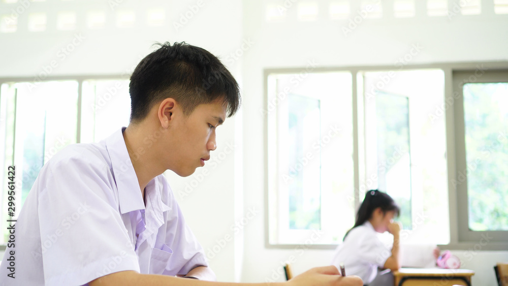 concentration of young asian student taking notes information for test or final exam from book seem serious in learning at high school classroom with group friends with Thai white shirt uniform concentration of young asian student taking notes information for test or final exam from book seem serious in learning at high school classroom with group friends with Thai white shirt uniform