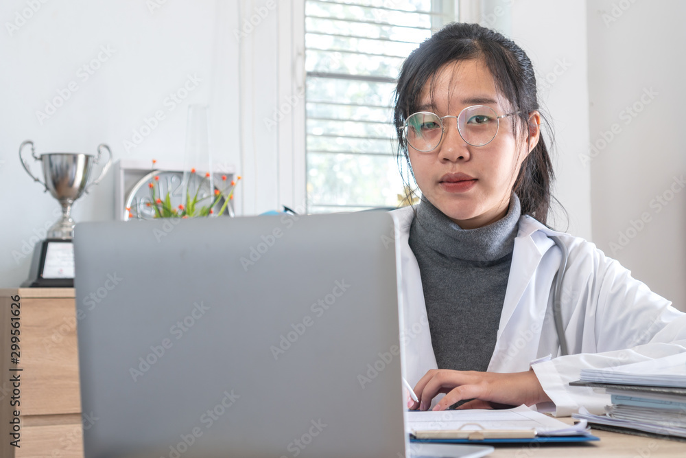 Healthcare and doctor's medical document file concept, Asian Doctor working with stethoscope, online recode patient prescriptions clipboard, input information to laptop computer on desk hospital room Healthcare and doctor's medical document file concept, Asian Doctor working with stethoscope, online recode patient prescriptions clipboard, input information to laptop computer on desk hospital room
