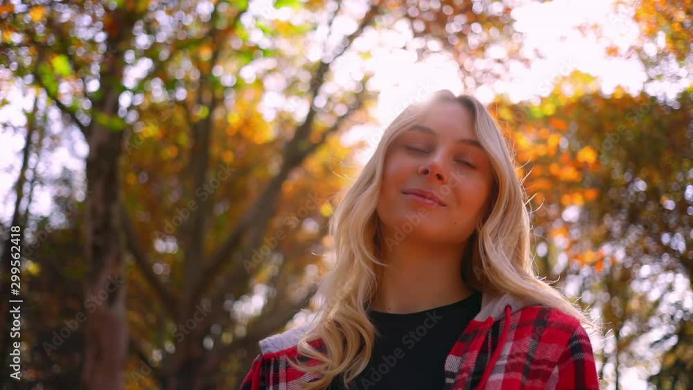 Portrait of pretty blonde woman on nature, young happy girl smiling at camera in autumn garden Portrait of pretty blonde woman on nature, young happy girl smiling at camera in autumn garden