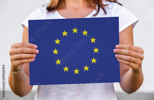 woman holds flag of European Union on paper sheet