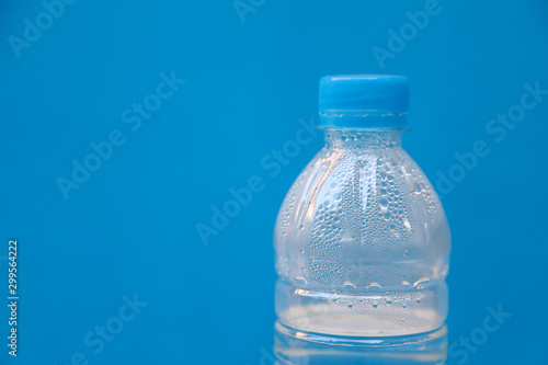 Closeup of a bottle of drinking water with blue background.