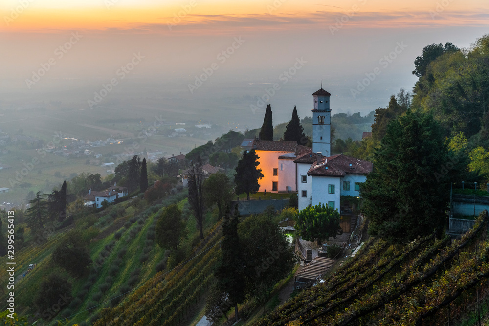 Sunset from the Cormons hill. Among fog, vineyards and fiery colors. Italy