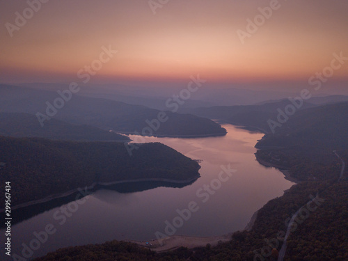 Beautiful drone shot over twists and turns of a river in Rhodope Mountains, Bulgaria. Magical light and a beautiful sunset.