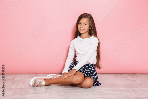 Girl child posing isolated over pink wall background photo