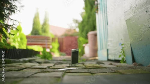 Mobile phone falls and breaks on the concrete ground in slow motion
