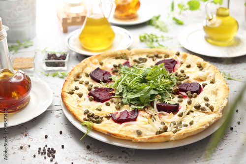 Pizza with mozzarella, caramelized beetroot, onion, capers and arugula.